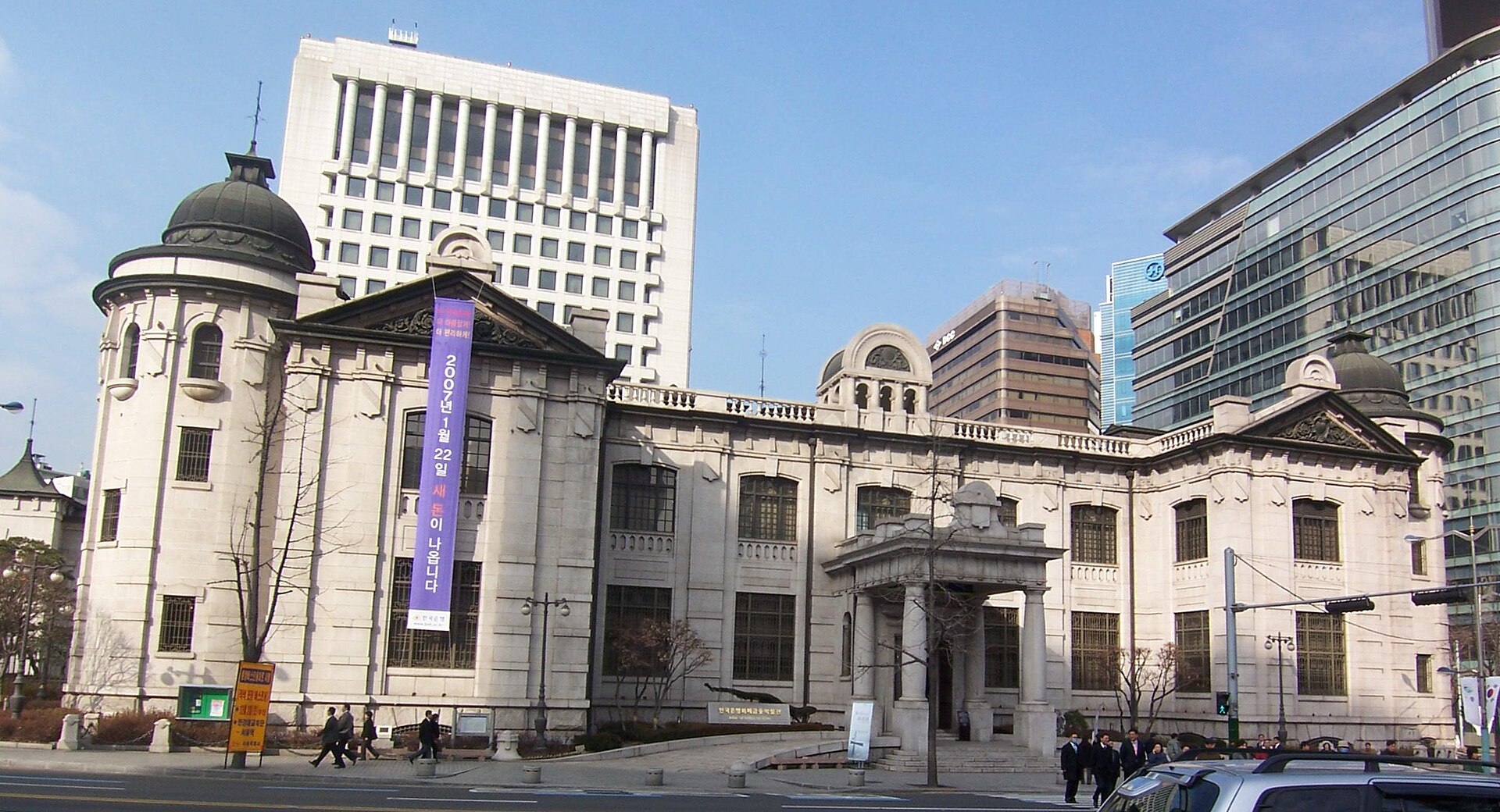 서울 중구 한국은행 옛 본관 건물과 뒤편의 현대식 고층 건물이 함께 보이는 겨울 낮 풍경